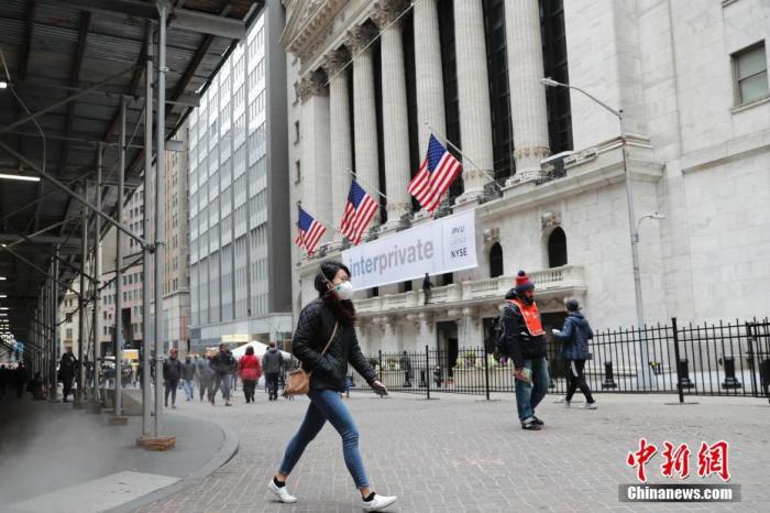 当地时间3月12日，一位戴口罩的民(mín)众走过纽约证券交易所。<a target='_blank' href='http://www.chinanews.com/'>中新(xīn)社</a>记者 廖攀 摄